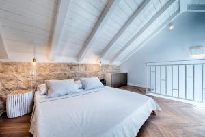 un grande letto bianco in una stanza con un muro di pietra di Studio Apartment Vicencina a Vis