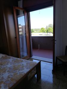 Villa Manuela في غرادو: غرفة نوم مع باب مفتوح على شرفة