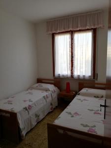 a bedroom with two beds and a window at Villa Manuela in Grado