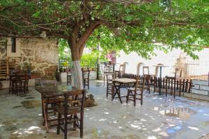 grupa stołów i krzeseł pod drzewem w obiekcie White City Pension w mieście Antalya