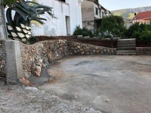 a stone retaining wall next to a building at Apartment Lola in Jelsa