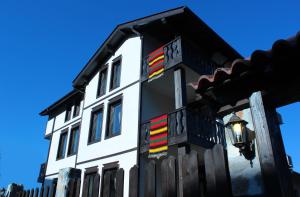 a white building with colorful stripes on the side of it at Topalovi Guest House in Zlatograd