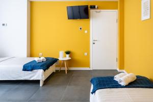 1 dormitorio con 2 camas y pared amarilla en Kostovski Rooms-near E75 to Greece, en Veles