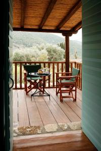 a porch with a table and chairs on a deck at Rizes in Psárion