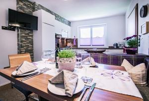 a dining table with wine glasses and a kitchen at Haus Finca in Neustift im Stubaital