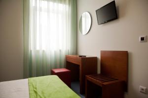 Uma televisão e/ou sistema de entretenimento em Hotel Comércio
