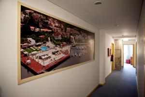 a large painting of a boat hanging on a wall at Hotel Comércio in Resende