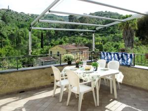 Un patio con una mesa y sillas en un balcón. en Apartment Casa Petrella - DOL137 by Interhome, en Dolcedo