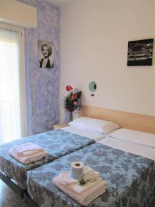 Dos camas en una habitación de hotel con toallas. en Hotel Villa Elia en Rímini