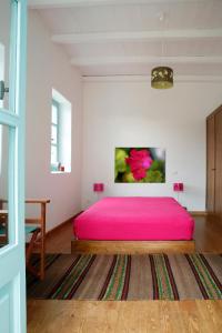 - une chambre avec un lit rose dans l'établissement Rizes, à Psárion