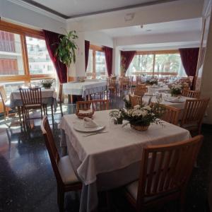 a dining room with tables and chairs and windows at Hotel Tanit in Benidorm