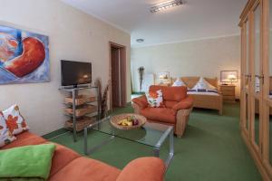 a living room with a couch and a tv at Gästehaus am Markt - Leisnig in Leisnig