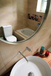 La salle de bains est pourvue d'un lavabo, d'une baignoire et d'un miroir. dans l'établissement Rizes, à Psárion
