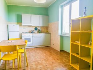eine Küche mit einem Tisch und gelben Stühlen in der Unterkunft La Casa del Mastro in Ardore Marina