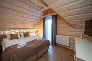 Posteľ alebo postele v izbe v ubytovaní "Osada Guty" - każdy domek posiada prywatne jacuzzi na wyłączność, w cenie pobytu - idealne miejsce na wypoczynek!