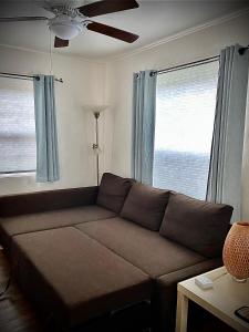 sala de estar con sofá y 2 ventanas en Blue Heron Cottages en San Diego