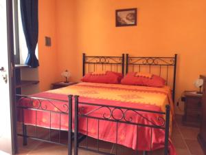 een slaapkamer met een bed met rode kussens erop bij IL Borgo 31 in Scapoli