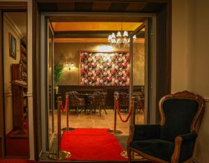 a room with a red carpet and a dining room at Hotel Capital with private wellness in Nitra