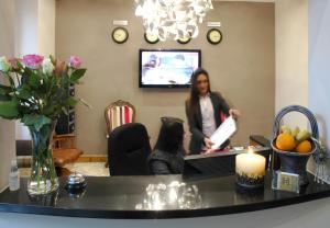 a woman standing in a waiting room at a hair salon at Homestay Hotel Heathrow in Hounslow