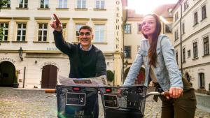 un homme et une femme debout à côté d'un vélo dans l'établissement Josephine Old Town Square Hotel - Czech Leading Hotels, à Prague