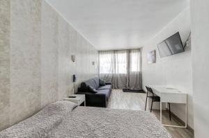 Un dormitorio con una cama, un sofá y una mesa. en Hôtel Vila, en Frontignan