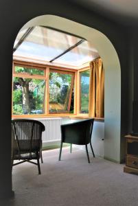Habitación con mesa, sillas y ventana en The Cottage Garden - A Herefordshire Retreat, en Ross-on-Wye
