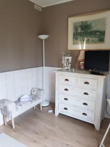 Arpaillargues-et-AureillacCHAMBRE D HOTES à 4 KMS D UZES " Chez Nadou "的客厅配有白色梳妆台和电视