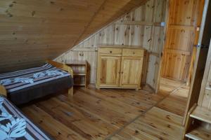 a log cabin with a bed and a wooden floor at Owk Korona in Mikoszewo