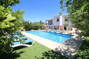 une villa avec piscine et chaises longues dans l'établissement Villa Sunset - San Antonio Bay, à Cala de Bou