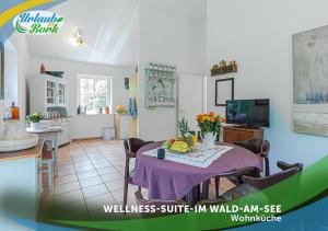 a kitchen and dining room with a table with fruit on it at Wellness-Suite-im-Wald-am-See in Kyritz