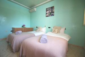two beds in a room with blue walls at Villa Sunset - San Antonio Bay in Cala de Bou