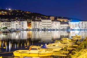 Un grupo de barcos atracados en un puerto por la noche en Hôtel Vila, en Frontignan