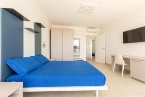 Un dormitorio con una cama azul y un escritorio. en Villa Punta Ristola by Perle di Puglia, en Leuca