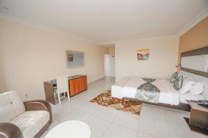 - une grande chambre avec un lit et un canapé dans l'établissement Fini Hotel Bobende, à Limbe