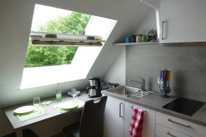 a kitchen with a table and a sink and a window at kleine Ferienwohnung am Wulfkamp in Velen