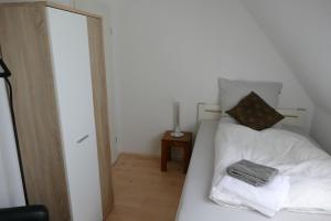 a bedroom with a white bed and a mirror at kleine Ferienwohnung am Wulfkamp in Velen