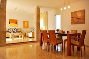 une salle à manger et un salon avec une table et des chaises dans l'établissement Villa Sunset - San Antonio Bay, à Cala de Bou