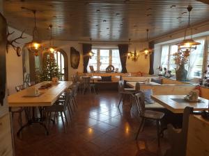 a restaurant with tables and chairs and a kitchen at Hotel Garni Forsthaus Ruhpolding incl Chiemgau Karte in Ruhpolding