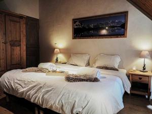 a bedroom with two beds and a painting on the wall at Le Cairn in Peisey-Nancroix