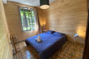 a bedroom with a blue bed in a wooden wall at Béhuard : Maison vue Loire in Behuard