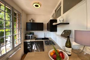 a kitchen with a bowl of fruit and a bottle of wine at Béhuard : Maison vue Loire in Behuard