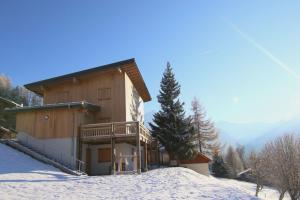 a log cabin in the snow with a balcony at Le Chalet in Peisey-Nancroix
