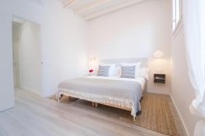 a white bedroom with a white bed with blue pillows at MARsuites Palma - Turismo de Interior TI 162 in Palma de Mallorca