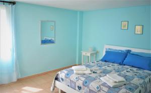 ein blaues Schlafzimmer mit einem Bett mit blauen Wänden in der Unterkunft Casa Vacanze Mameli in Bari Sardo