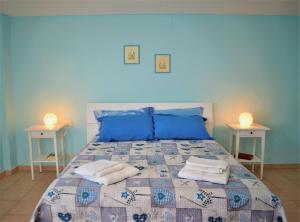 ein blaues Schlafzimmer mit einem Bett mit Handtüchern darauf in der Unterkunft Casa Vacanze Mameli in Bari Sardo