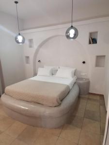 a bedroom with a bed with two lights above it at Sahara Apartments in Kastraki