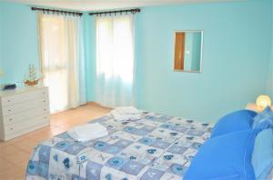 ein blaues Schlafzimmer mit einem Bett und einer Kommode in der Unterkunft Casa Vacanze Mameli in Bari Sardo