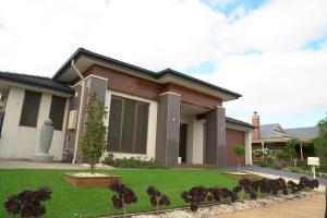a house with a green lawn in front of it at Stylish Luxe House For Big Group Near Shopping Center in Point Cook