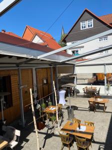 eine Außenterrasse mit Tischen, Stühlen und Sonnenschirmen in der Unterkunft Hotel-Gasthaus-Kraft in Schauenburg