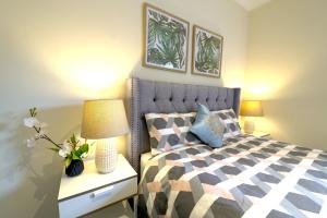 a bedroom with a bed and a table with a lamp at Stylish Luxe House For Big Group Near Shopping Center in Point Cook